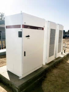 a row of white energy storage containers in a single row outdoors